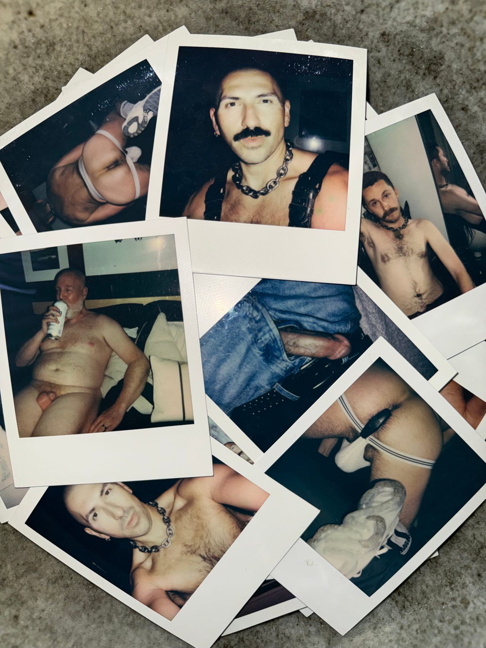 A scattered pile of Polaroid photographs of men, shot on a concrete floor.